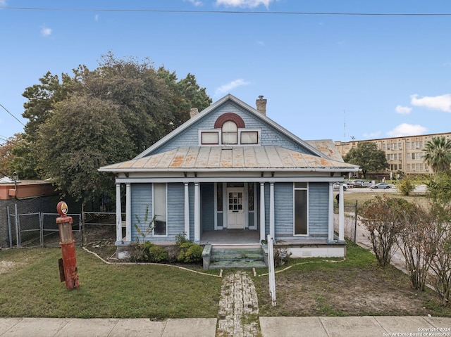 bungalow featuring covered porch and a front yard