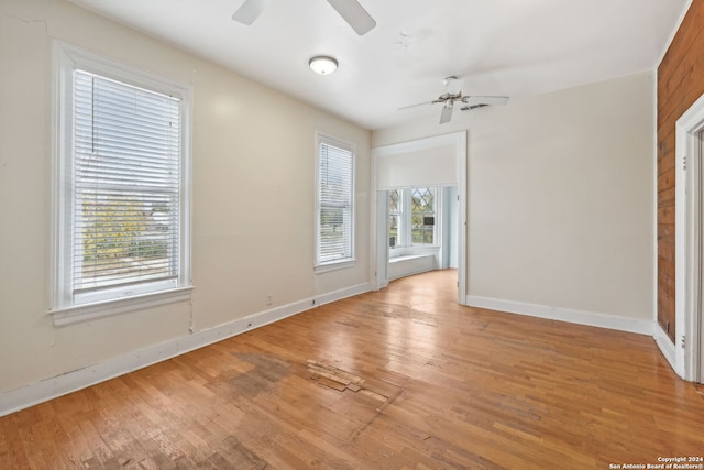 empty room with wooden walls and light hardwood / wood-style flooring