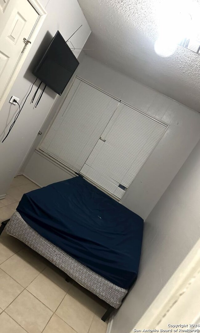 tiled bedroom featuring a textured ceiling