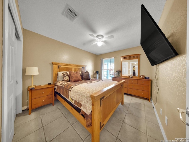 tiled bedroom featuring ceiling fan, a closet, and a textured ceiling