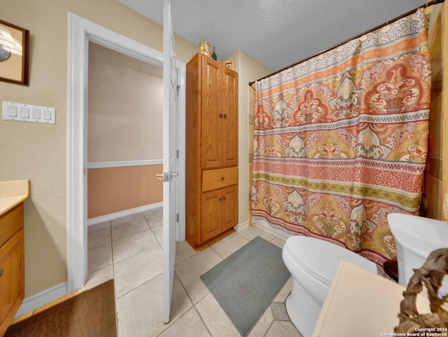 bathroom featuring toilet, a textured ceiling, vanity, and tile patterned floors