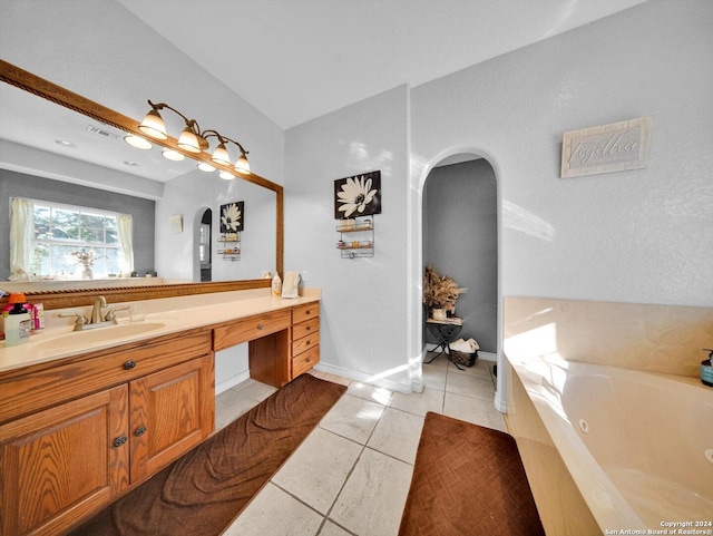 bathroom featuring tile patterned floors, tiled bath, and vanity