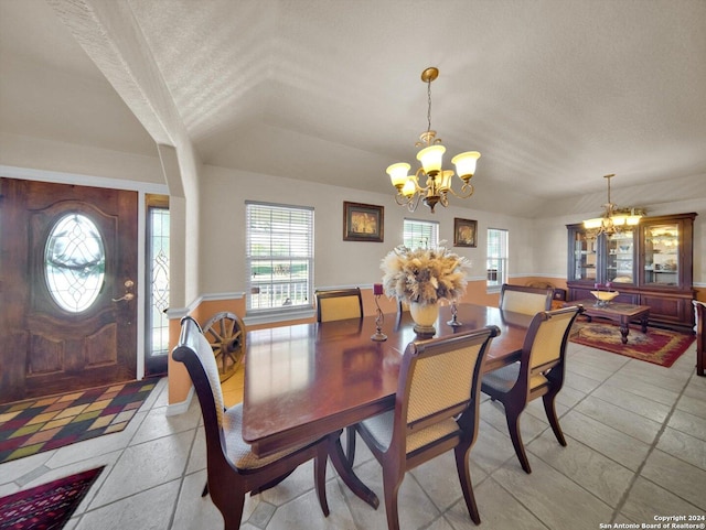 tiled dining space with a chandelier and a textured ceiling