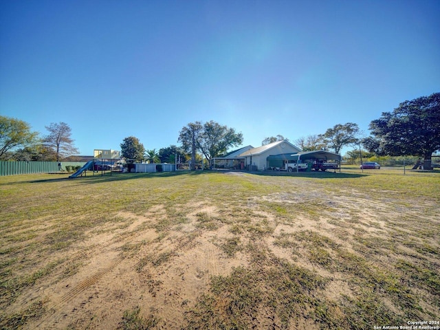 view of yard featuring a carport and a playground