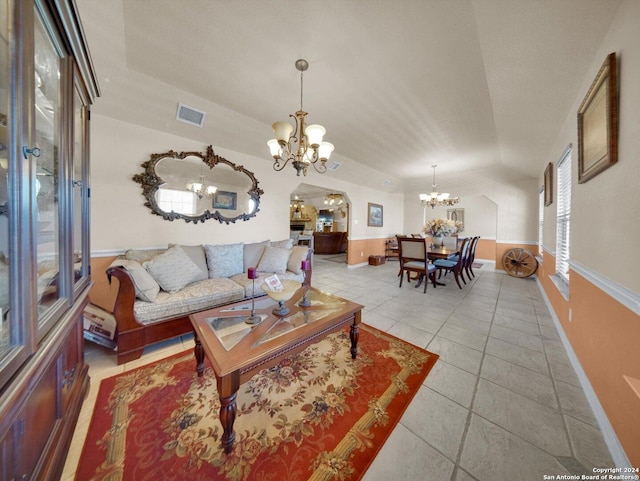 living room featuring vaulted ceiling, light tile patterned floors, and an inviting chandelier