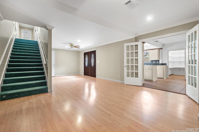 unfurnished living room featuring french doors, light wood-type flooring, ceiling fan, and crown molding