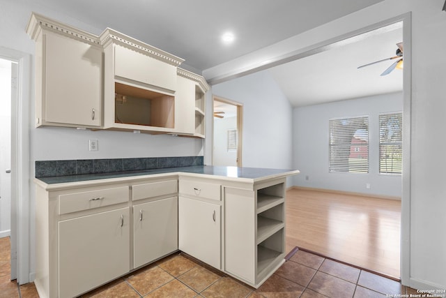 kitchen with kitchen peninsula, ceiling fan, and light wood-type flooring