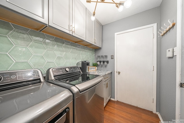 laundry room with cabinets, independent washer and dryer, and hardwood / wood-style flooring