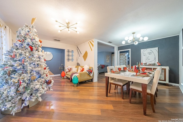 dining room featuring hardwood / wood-style floors, a textured ceiling, and a notable chandelier