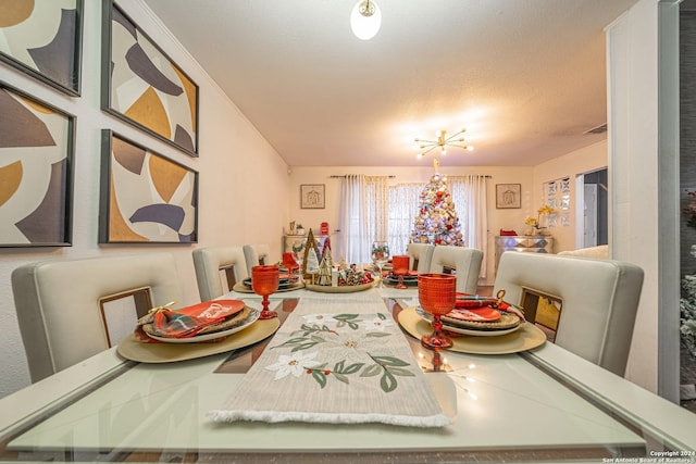 dining room featuring a textured ceiling and an inviting chandelier