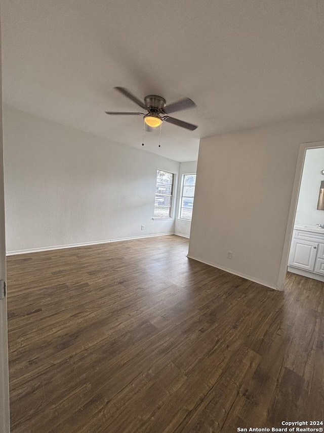 empty room with dark wood-type flooring and ceiling fan