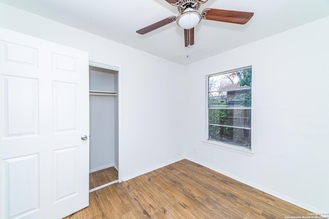 unfurnished bedroom featuring ceiling fan, hardwood / wood-style floors, and a closet