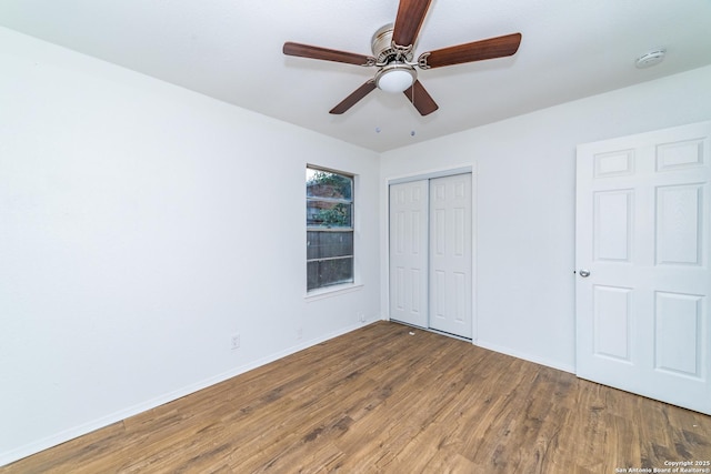 unfurnished bedroom with ceiling fan, a closet, and hardwood / wood-style flooring