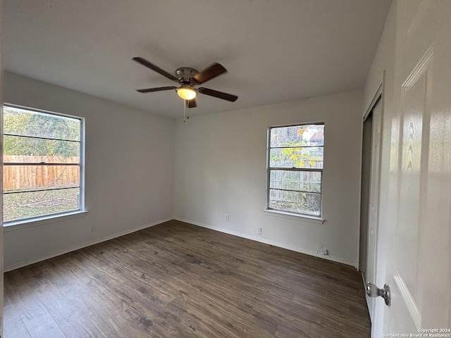 empty room with ceiling fan and dark wood-type flooring