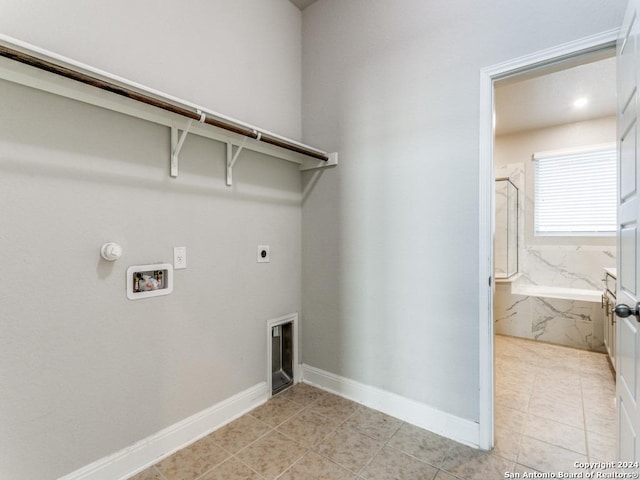 clothes washing area with washer hookup, electric dryer hookup, light tile patterned flooring, and hookup for a gas dryer