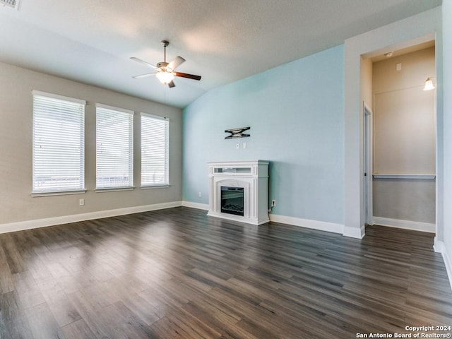 unfurnished living room featuring a high end fireplace, vaulted ceiling, dark hardwood / wood-style floors, ceiling fan, and a textured ceiling