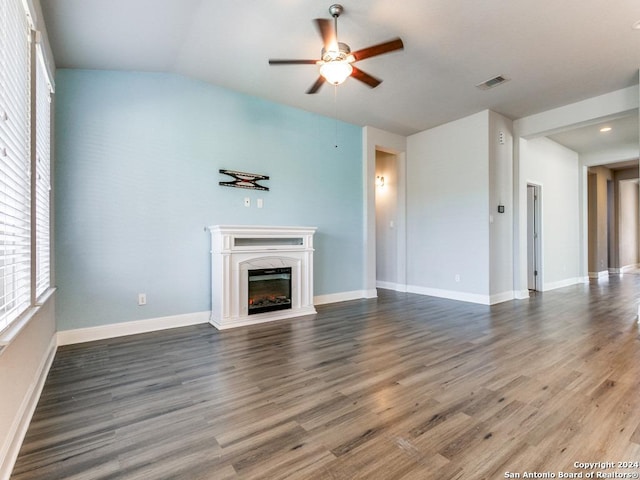 unfurnished living room with dark hardwood / wood-style floors, ceiling fan, a high end fireplace, and vaulted ceiling