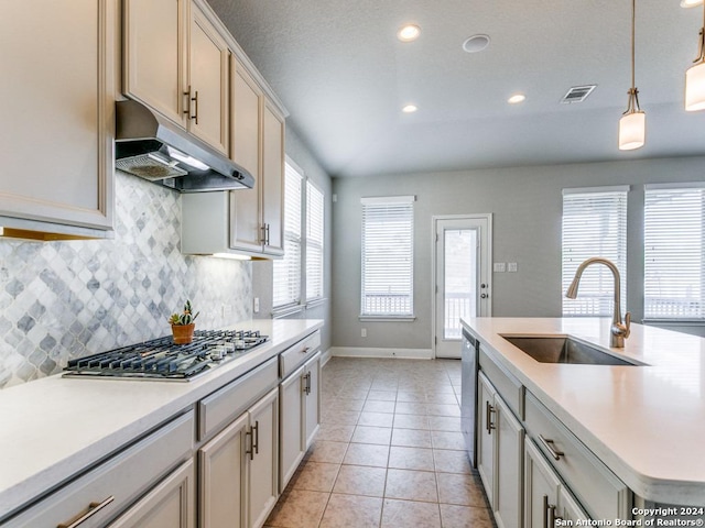 kitchen featuring appliances with stainless steel finishes, tasteful backsplash, sink, decorative light fixtures, and light tile patterned flooring