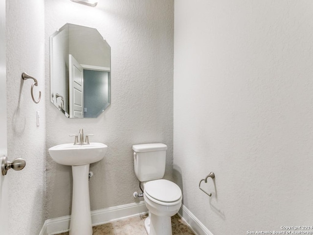 bathroom with tile patterned flooring, toilet, and sink