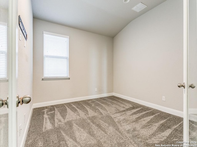 unfurnished room with carpet flooring and vaulted ceiling