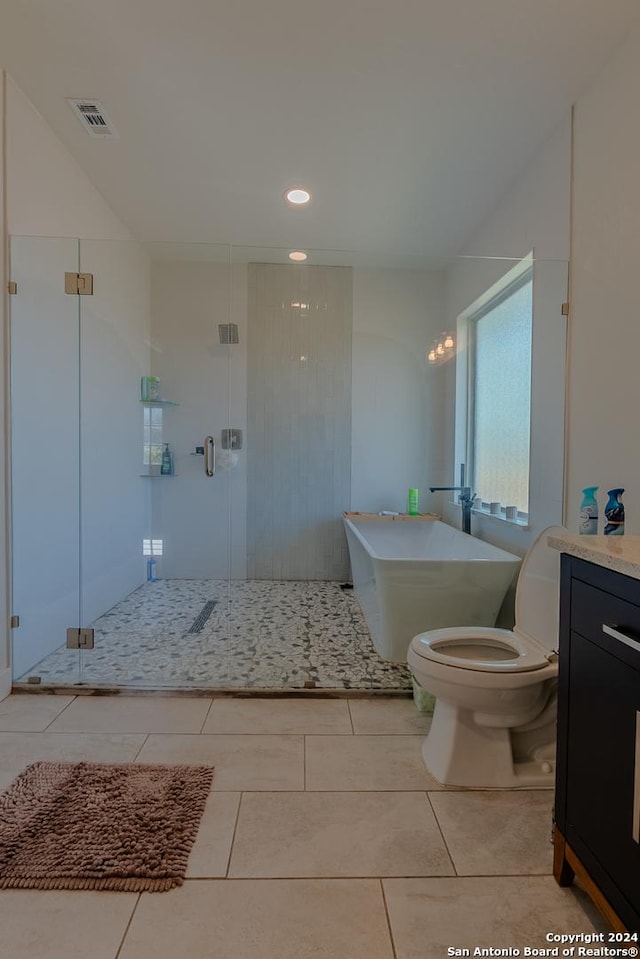 bathroom featuring tile patterned flooring, vanity, toilet, and a shower with door