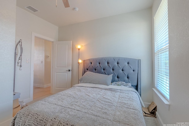 bedroom with ceiling fan, light wood-type flooring, and multiple windows