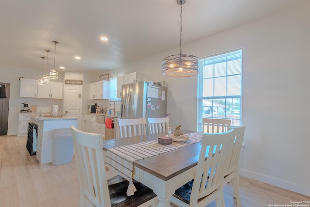 dining area featuring light hardwood / wood-style floors and an inviting chandelier