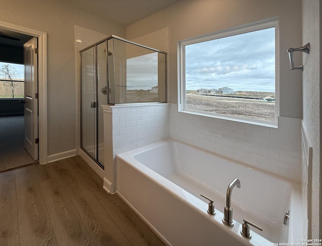 bathroom featuring shower with separate bathtub and hardwood / wood-style flooring