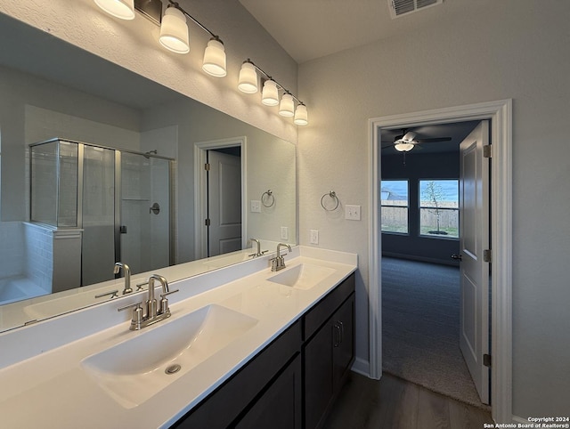 bathroom with hardwood / wood-style flooring, ceiling fan, a shower with shower door, and vanity