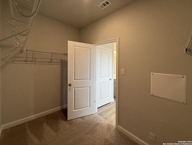 spacious closet featuring light carpet