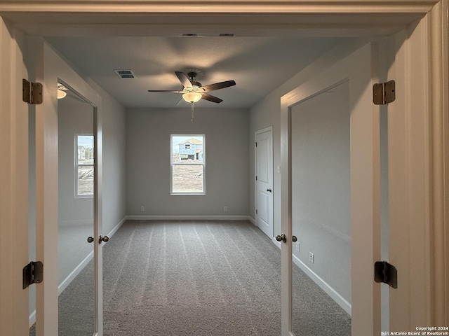 carpeted spare room featuring ceiling fan