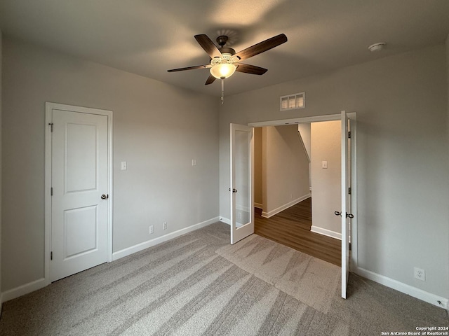 unfurnished bedroom featuring carpet, ceiling fan, and french doors