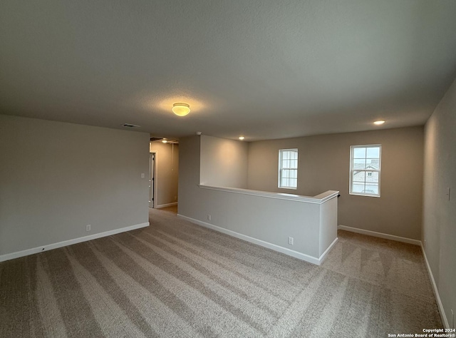 carpeted spare room with a textured ceiling