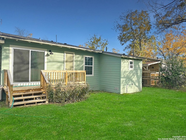 back of property featuring a lawn and a deck