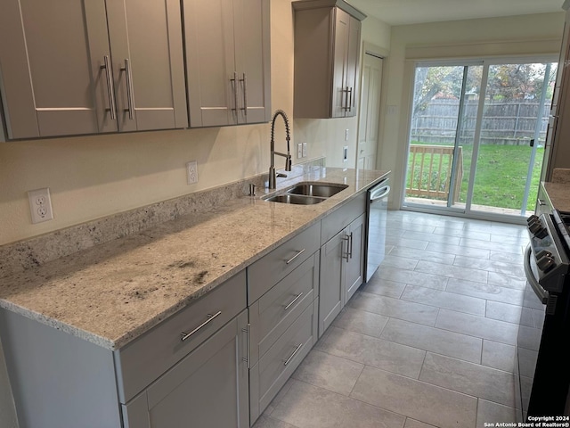 kitchen with gray cabinetry, dishwasher, light stone countertops, and a wealth of natural light