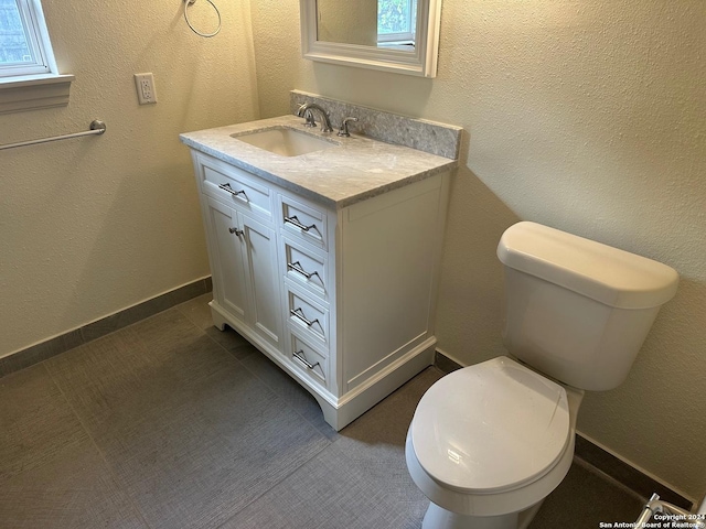 bathroom with vanity, a healthy amount of sunlight, and toilet