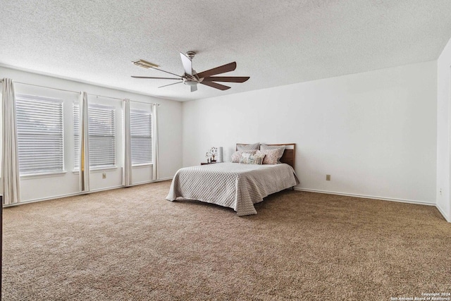 bedroom featuring carpet flooring, ceiling fan, and a textured ceiling