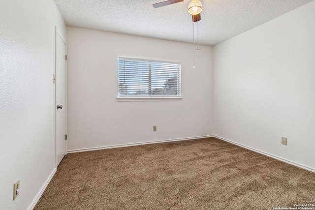 carpeted spare room with baseboards, a ceiling fan, and a textured ceiling