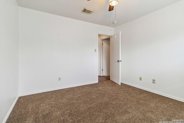 spare room featuring visible vents, baseboards, ceiling fan, carpet, and a textured ceiling