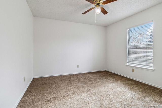 carpeted empty room with ceiling fan, a textured ceiling, and baseboards