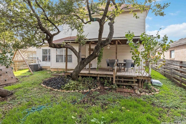 rear view of property featuring fence and a deck