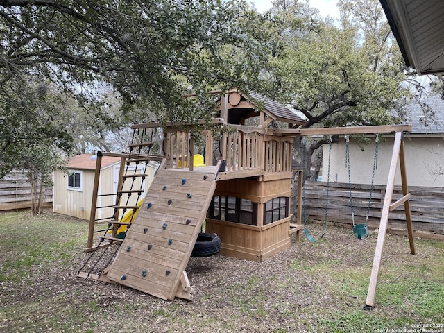 view of playground featuring an outbuilding and fence