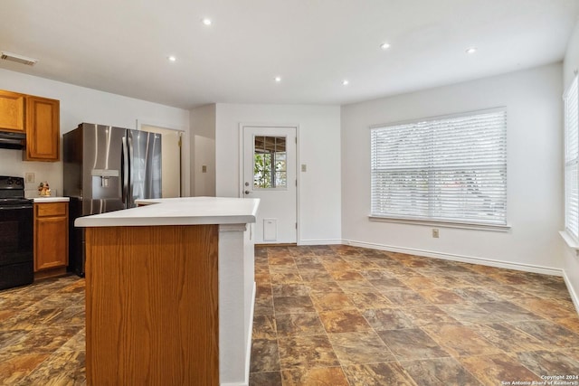 kitchen with stainless steel fridge with ice dispenser, electric range, a kitchen island, and exhaust hood