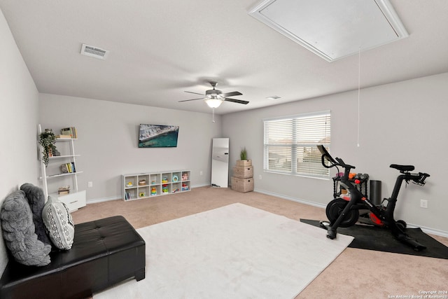 workout room featuring ceiling fan and light colored carpet