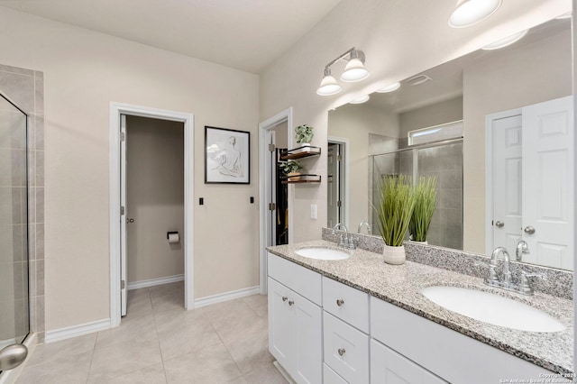 bathroom featuring tile patterned flooring, vanity, and a shower with door