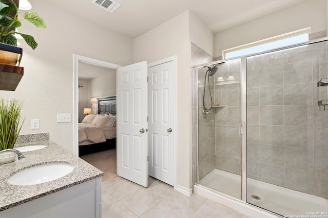 bathroom featuring tile patterned flooring, vanity, and a shower with shower door