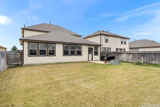 back of house featuring a patio area and a lawn