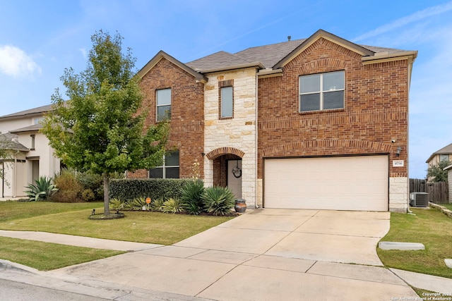 view of front of home featuring central AC, a front yard, and a garage