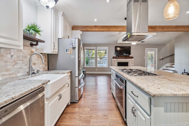 kitchen with appliances with stainless steel finishes, light wood-type flooring, island range hood, and white cabinetry