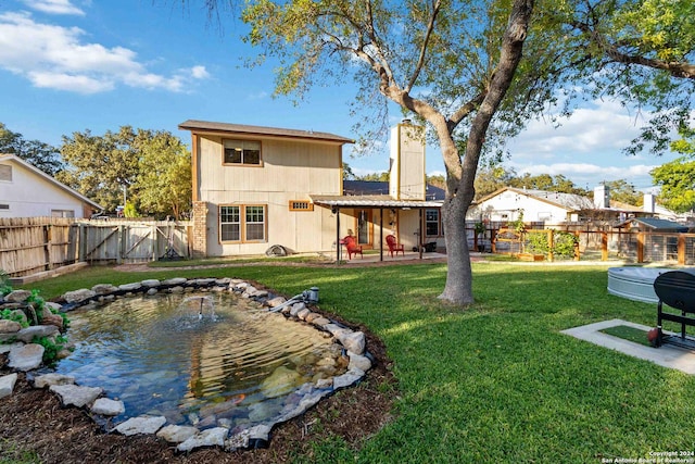 rear view of property with a lawn and a patio